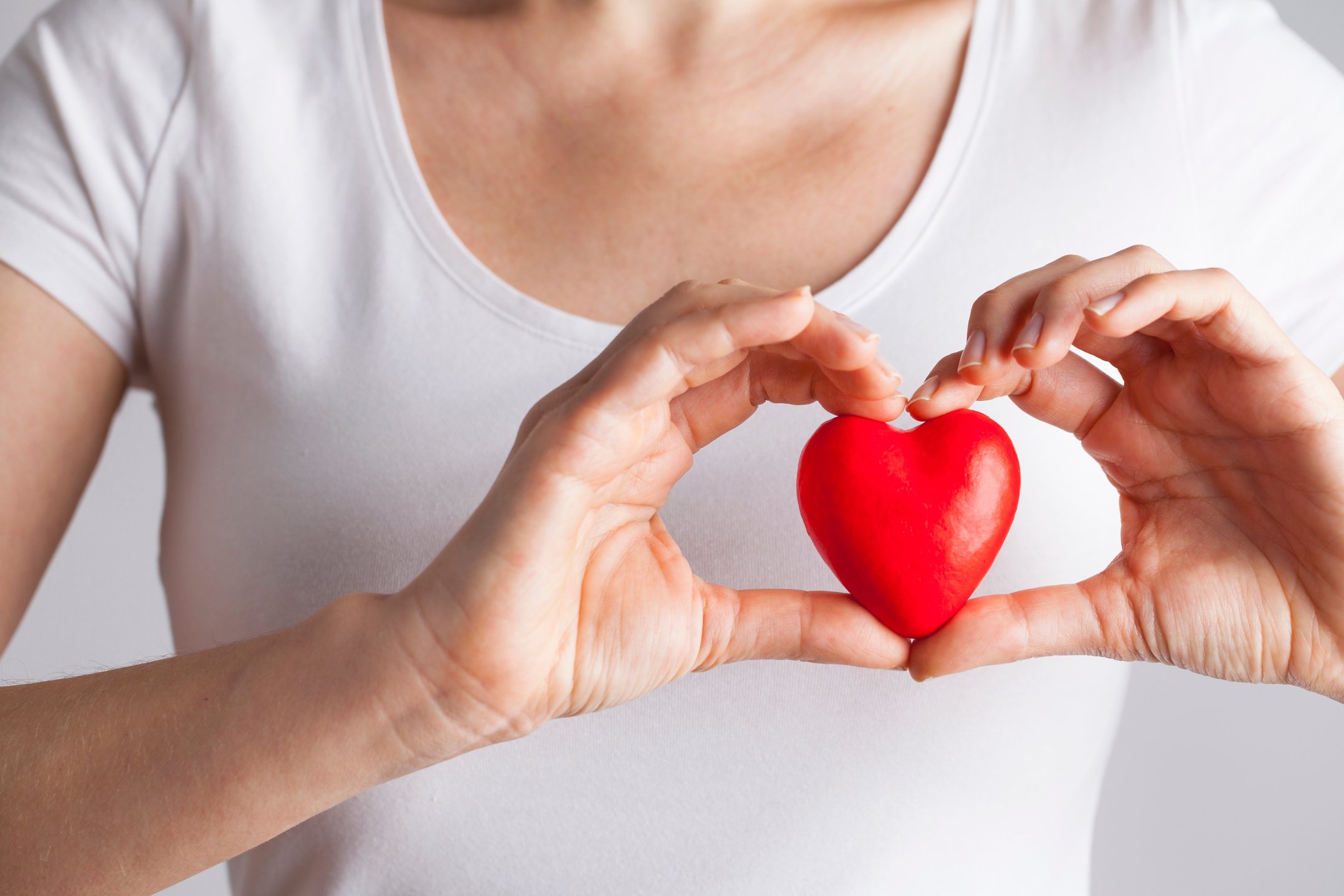 Young woman holding red heart, health insurance, donation, love concept