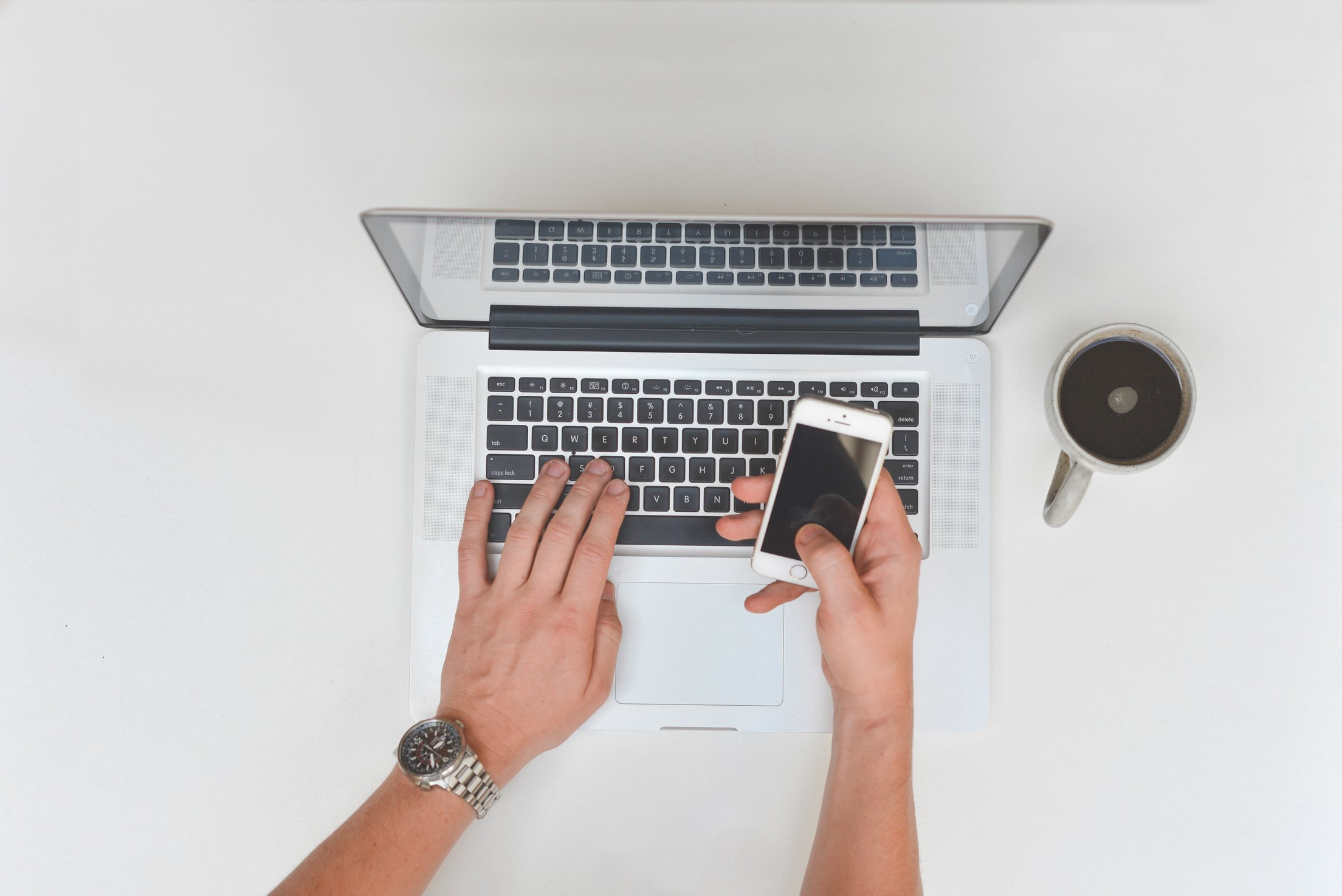 Person Using Smartphone and Laptop